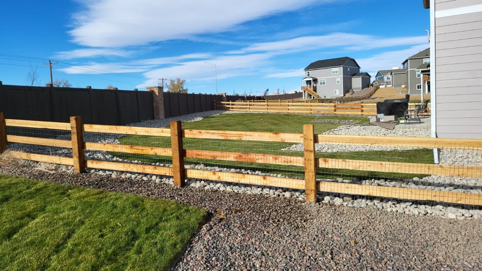 Wood fencing with landscaped lawn and rock borders